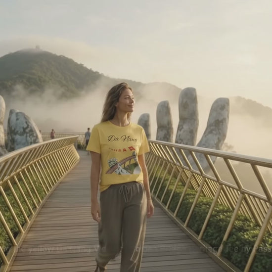 Model wearing the yellow Da Nang Vietnam Golden Bridge Heritage Tee by Passport Outfitters